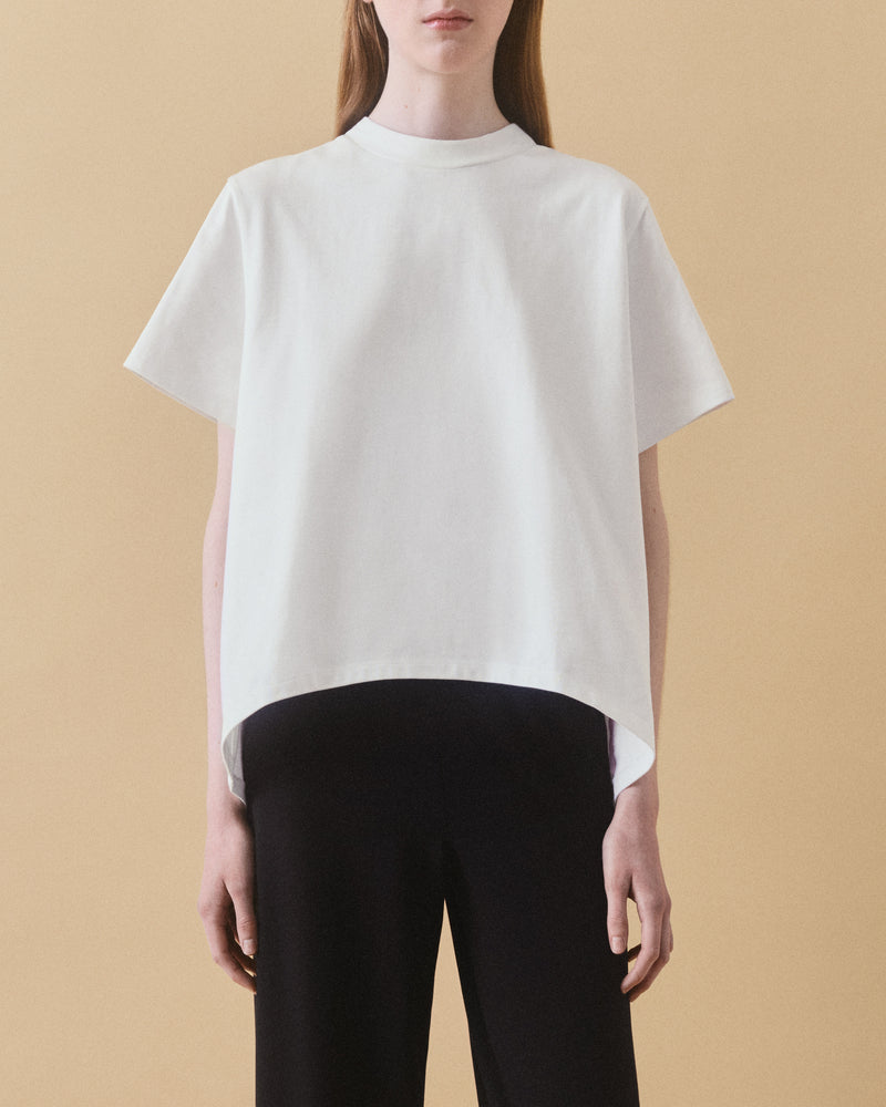 Off-white oversized organic cotton t-shirt with curved hem, styled with black trousers – Dhoemi Bend