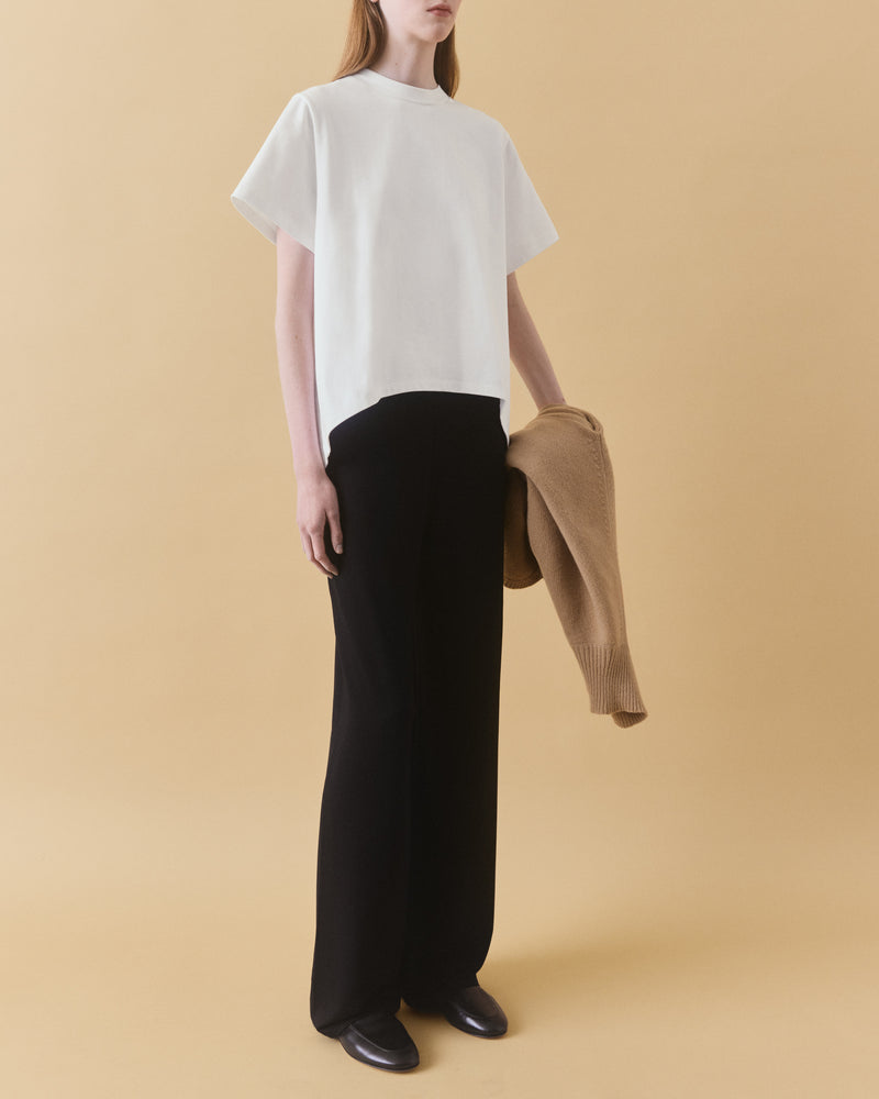 Off-white oversized organic cotton t-shirt styled with black trousers and camel knitwear – Dhoemi Bend