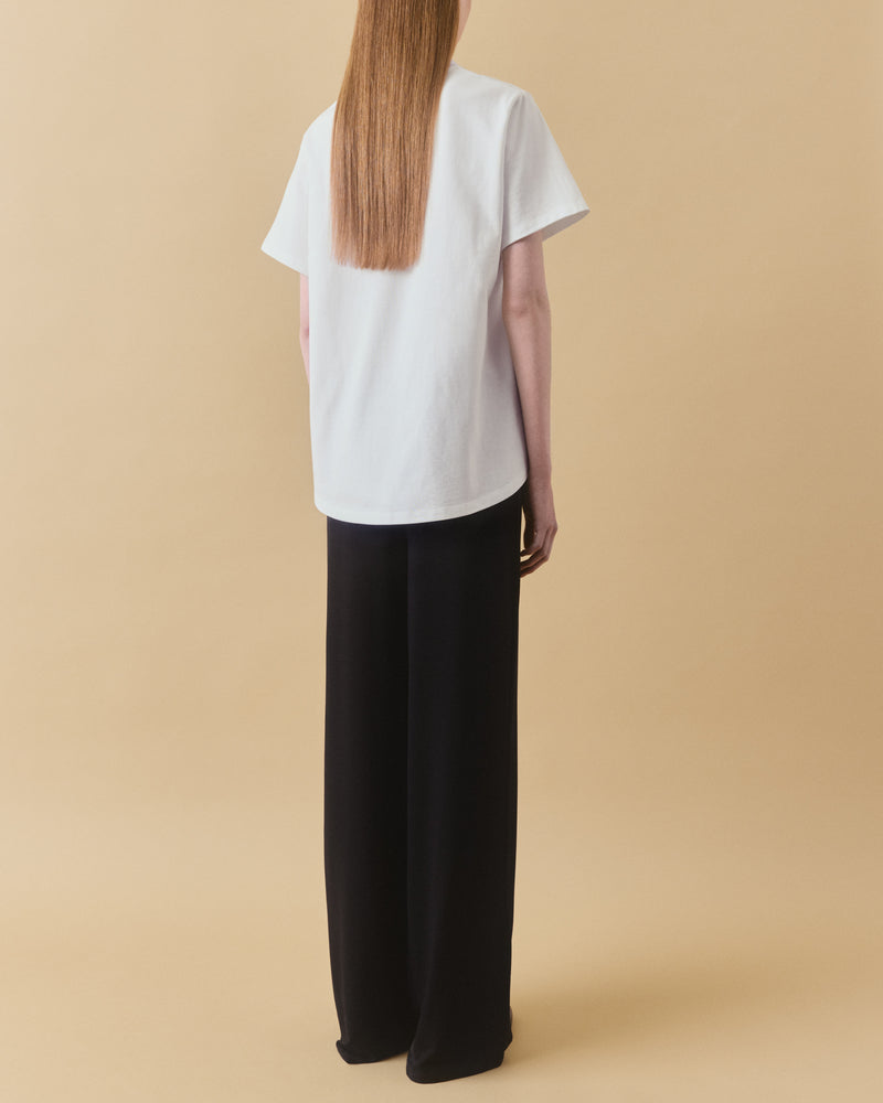Off-white oversized organic cotton t-shirt with curved hem, back view – Dhoemi Bend Tee