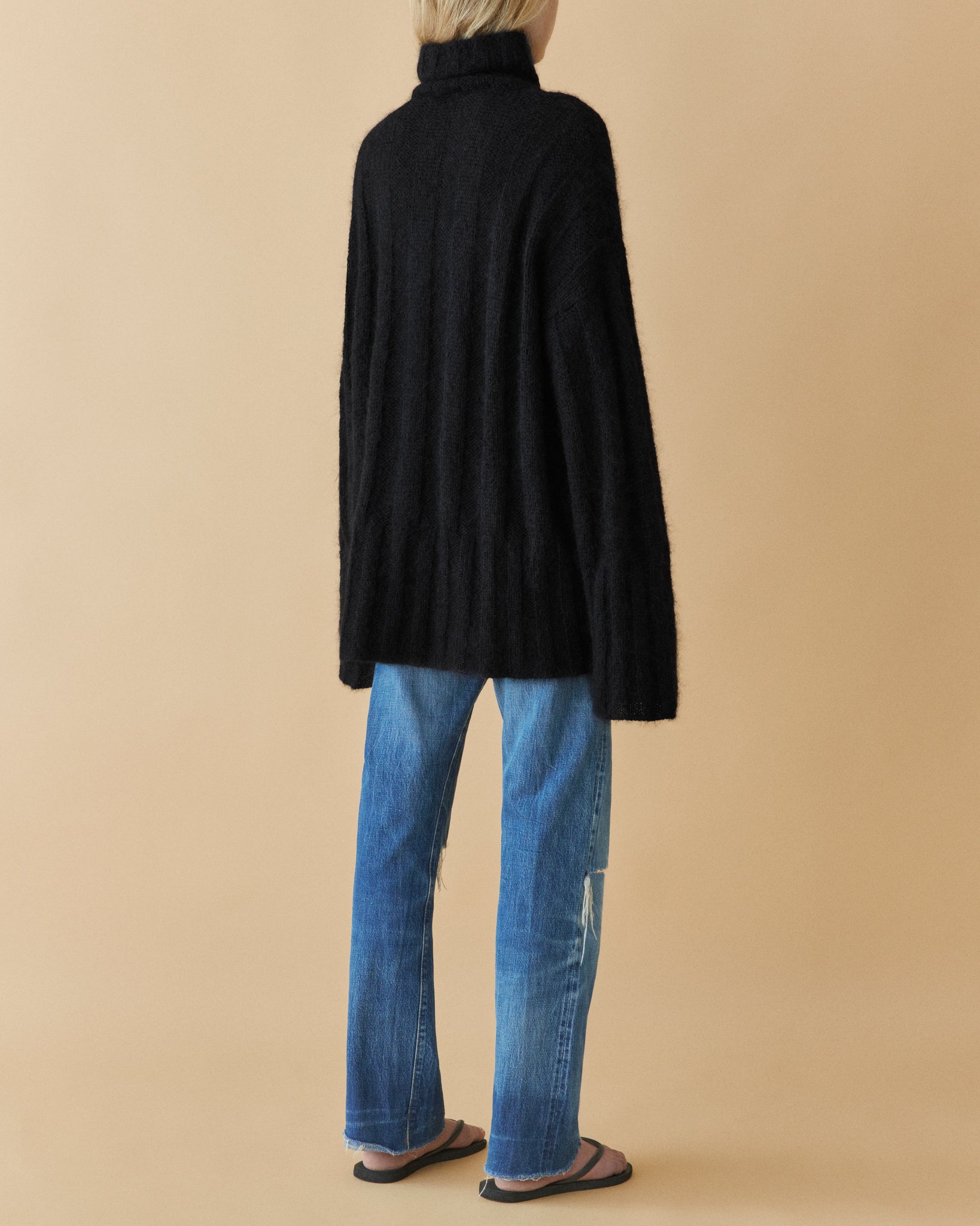 Black voluminous mohair rib knit turtleneck, side view styled with jeans – Dhoemi
